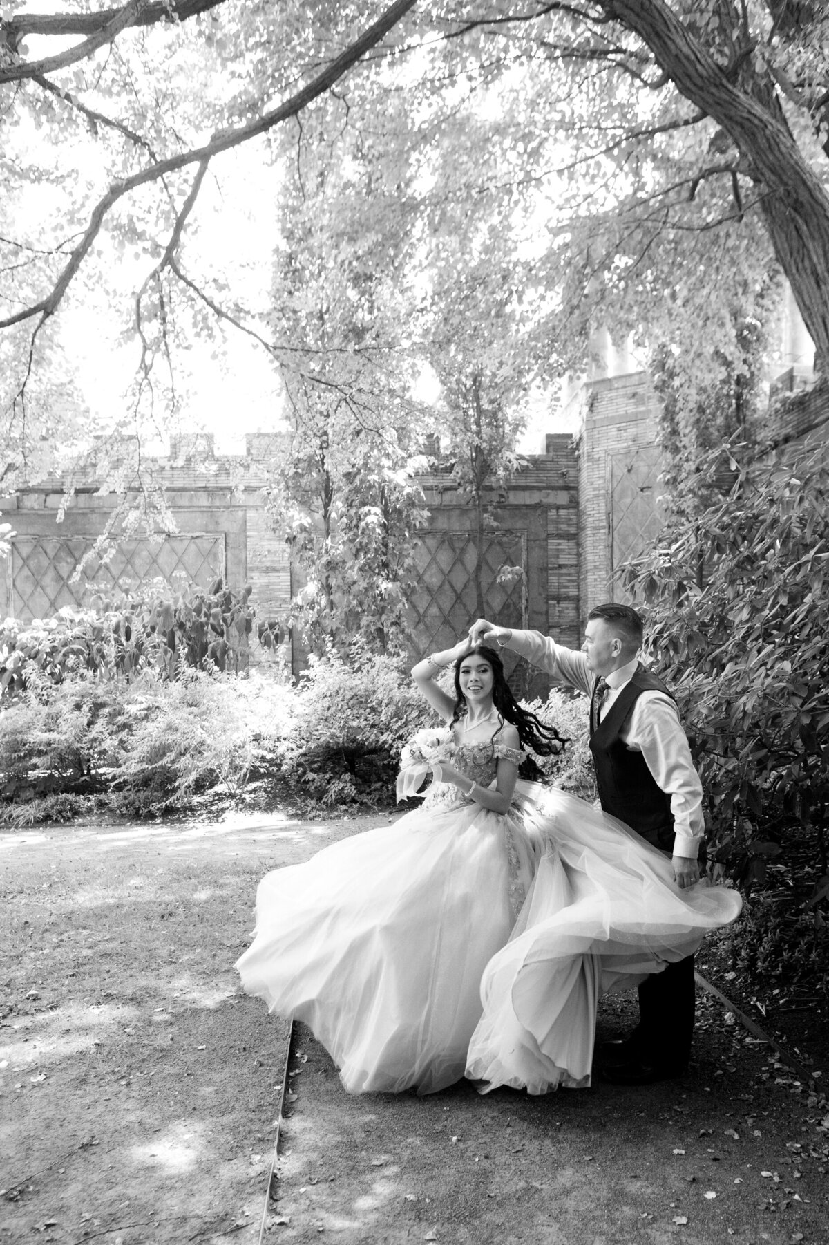 Black and white photo of teenage girl twirling Untermeyer Park New York Westchester quinceanera Photographer Milestone images