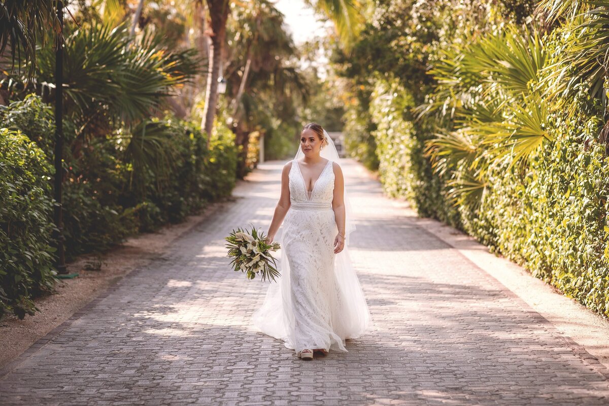 Bride walking down path before ceremony at wedding in Riviera Maya.