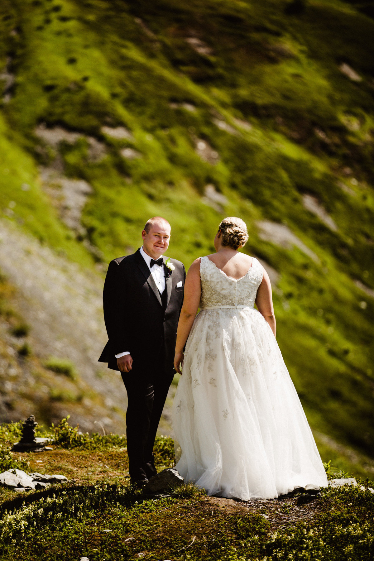 groom chokes back tears during first look on mountaintop at alyeska