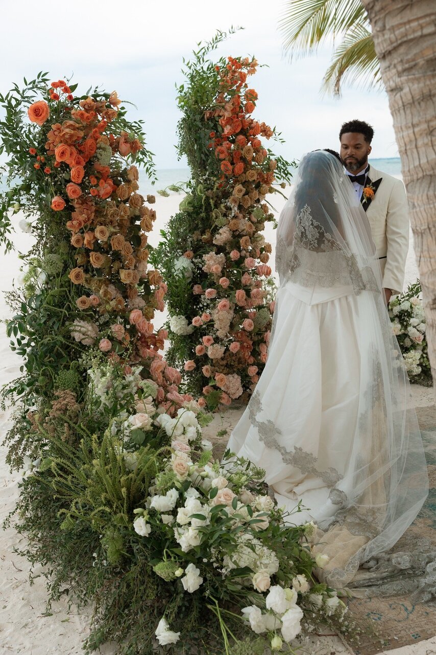 a couple posing in a wedding dress beside flowers