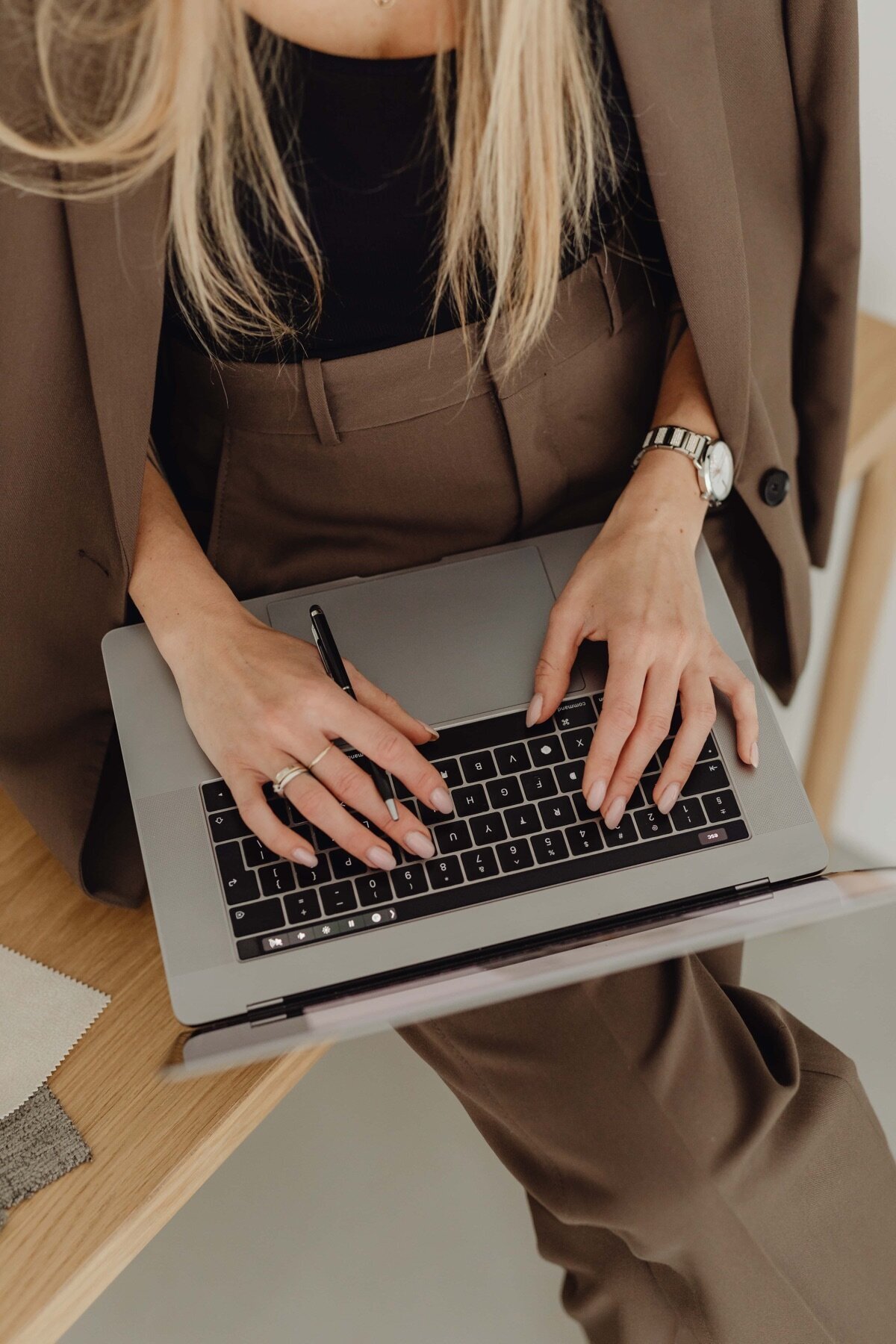 kaboompics_young-entrepreneur-dressed-in-brown-suit-holds-laptop-27938