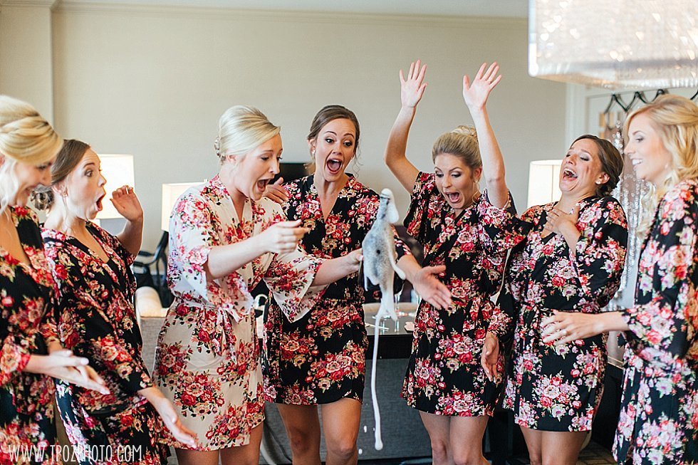 bridesmaids popping champagne bottles