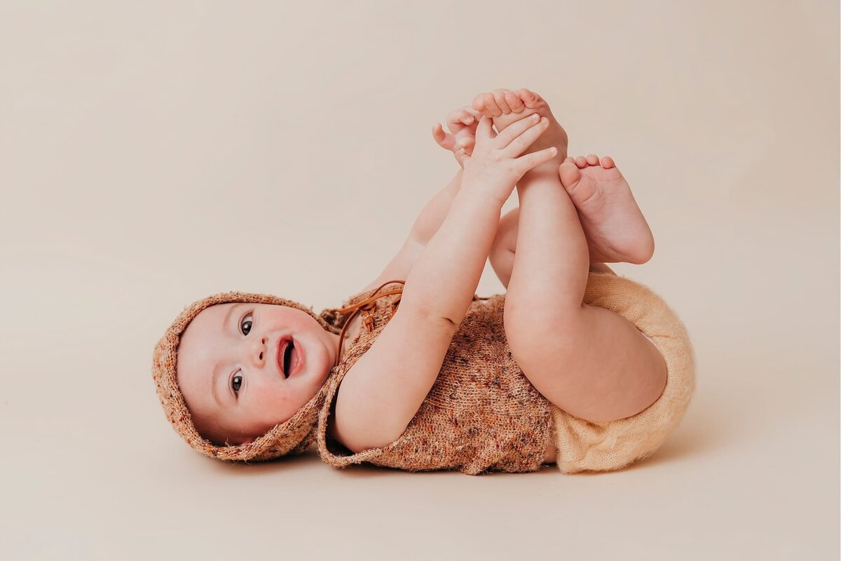 laughing baby holding toes