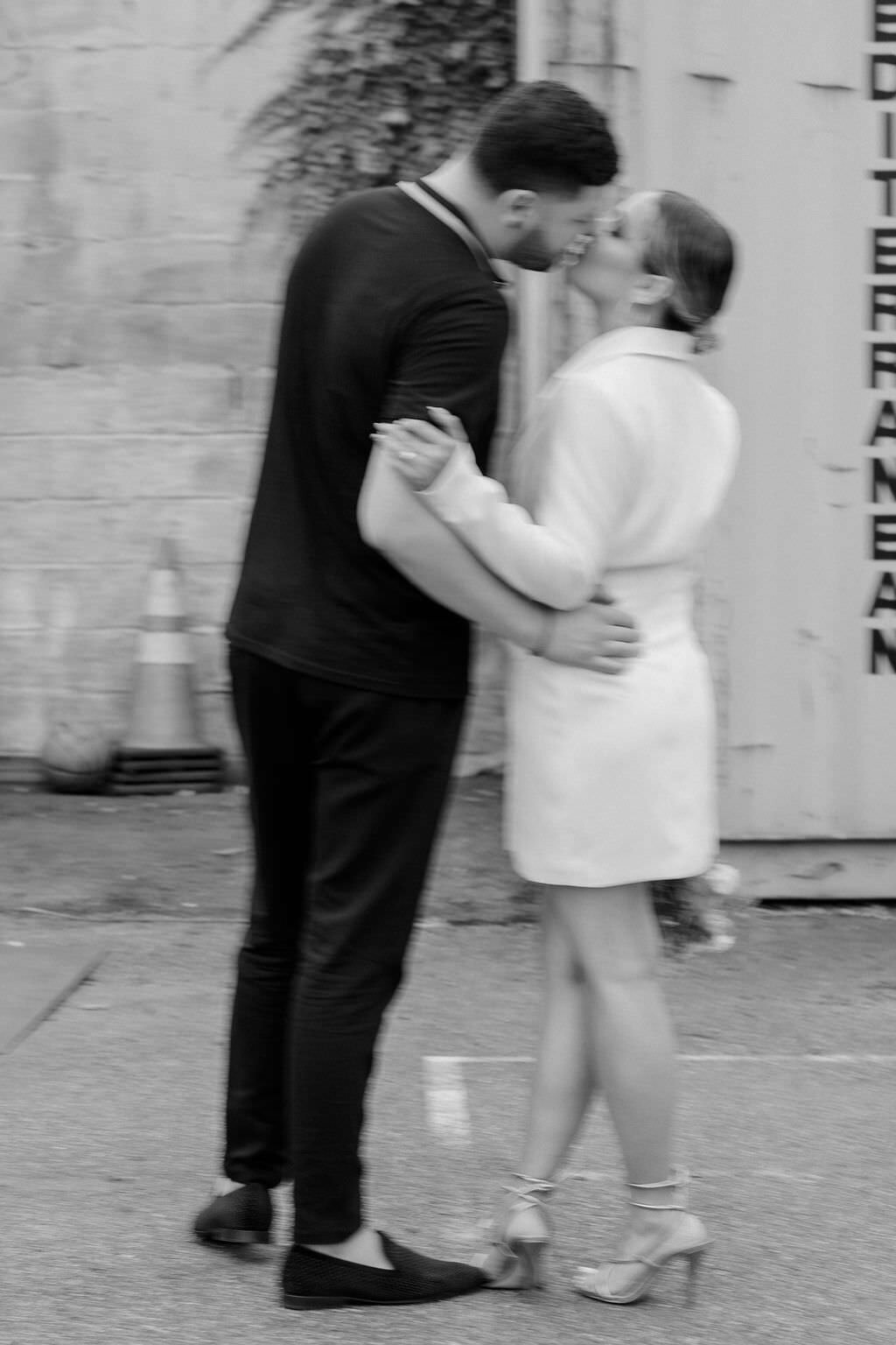 blurred black and white photo of a bride and groom kissing