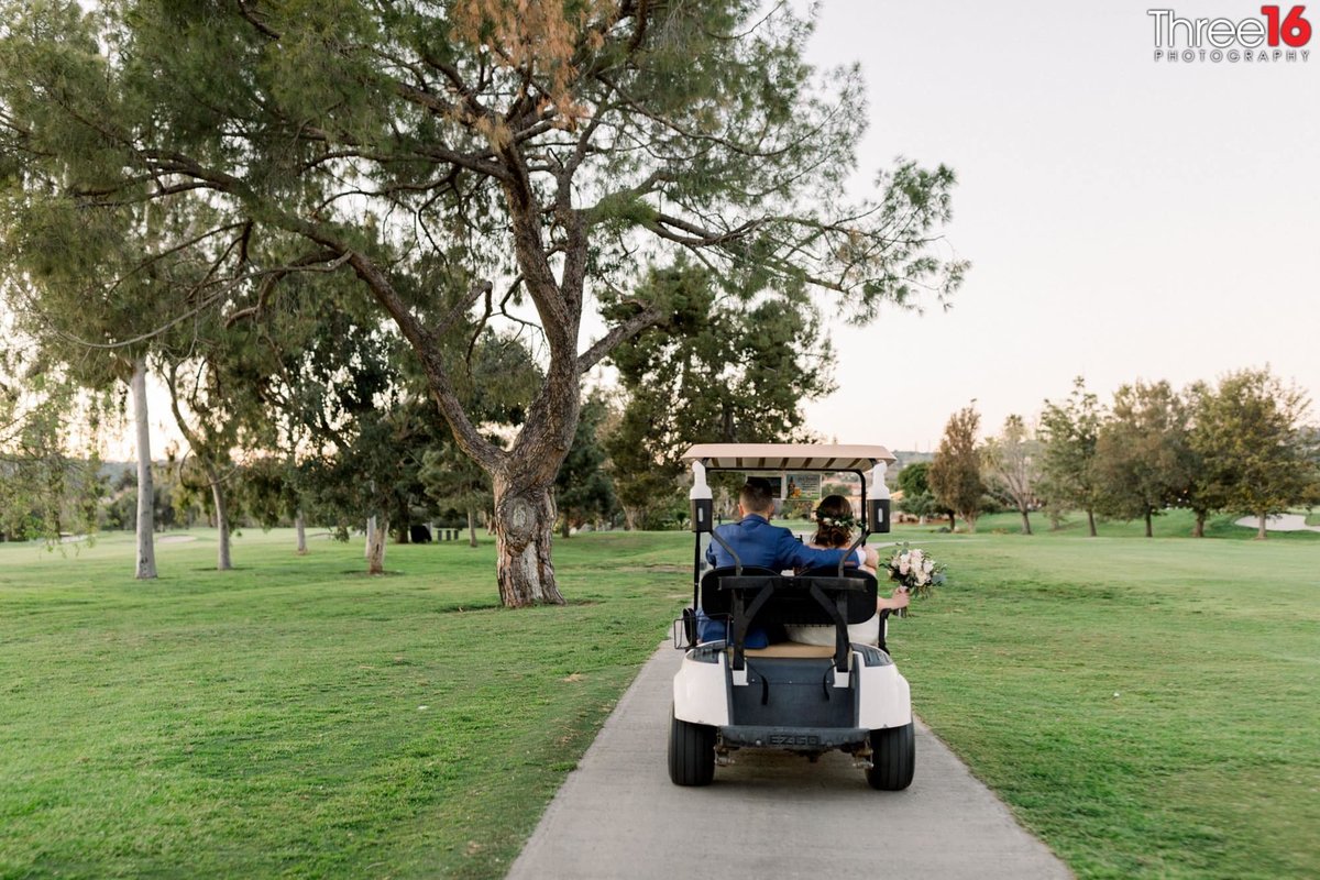 Bride and Groom go for a ride in a golf cart on the grounds of San Juan Hills Golf Club in San Juan Capistrano