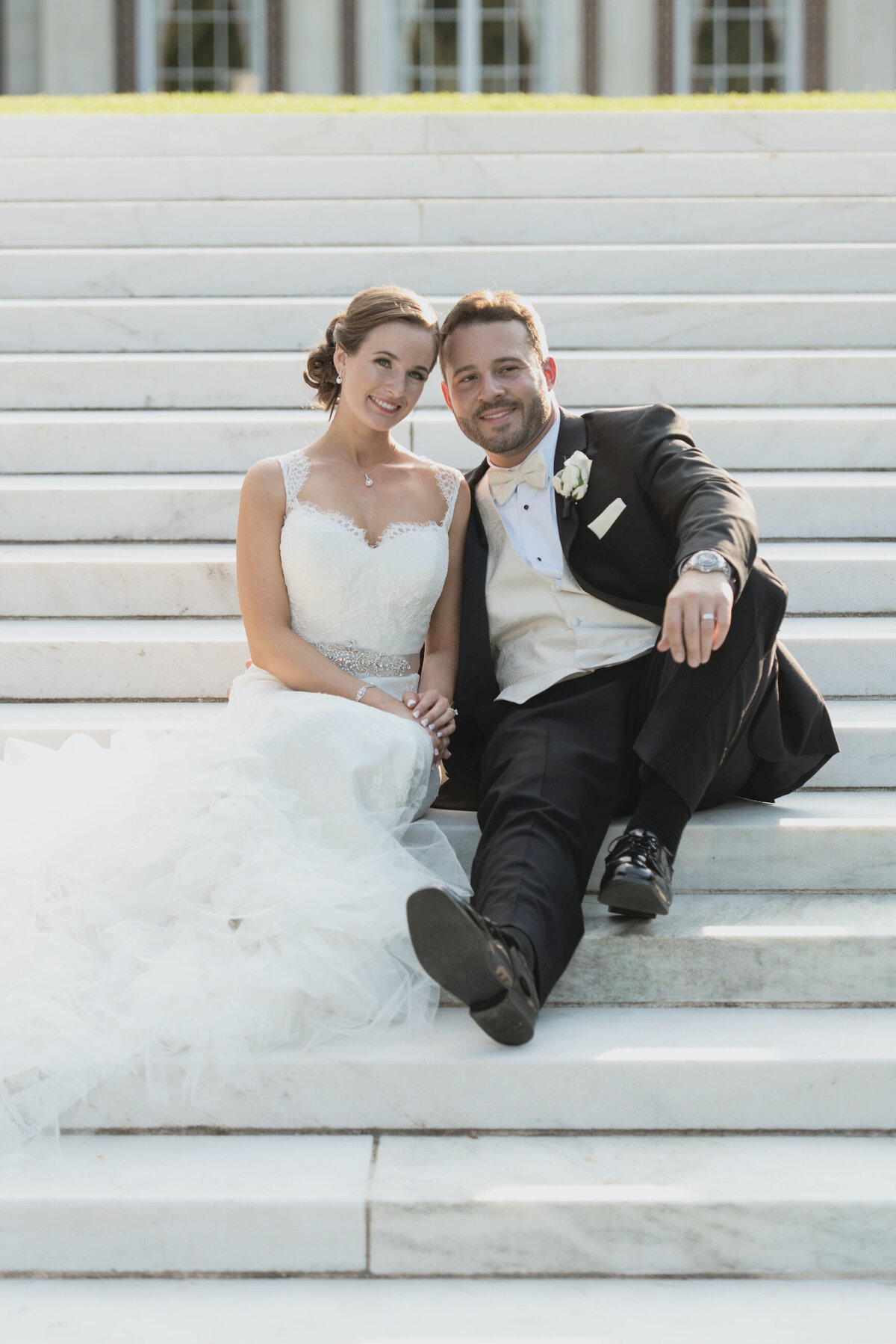 bride and groom sitting on the steps at de Seversky Mansion