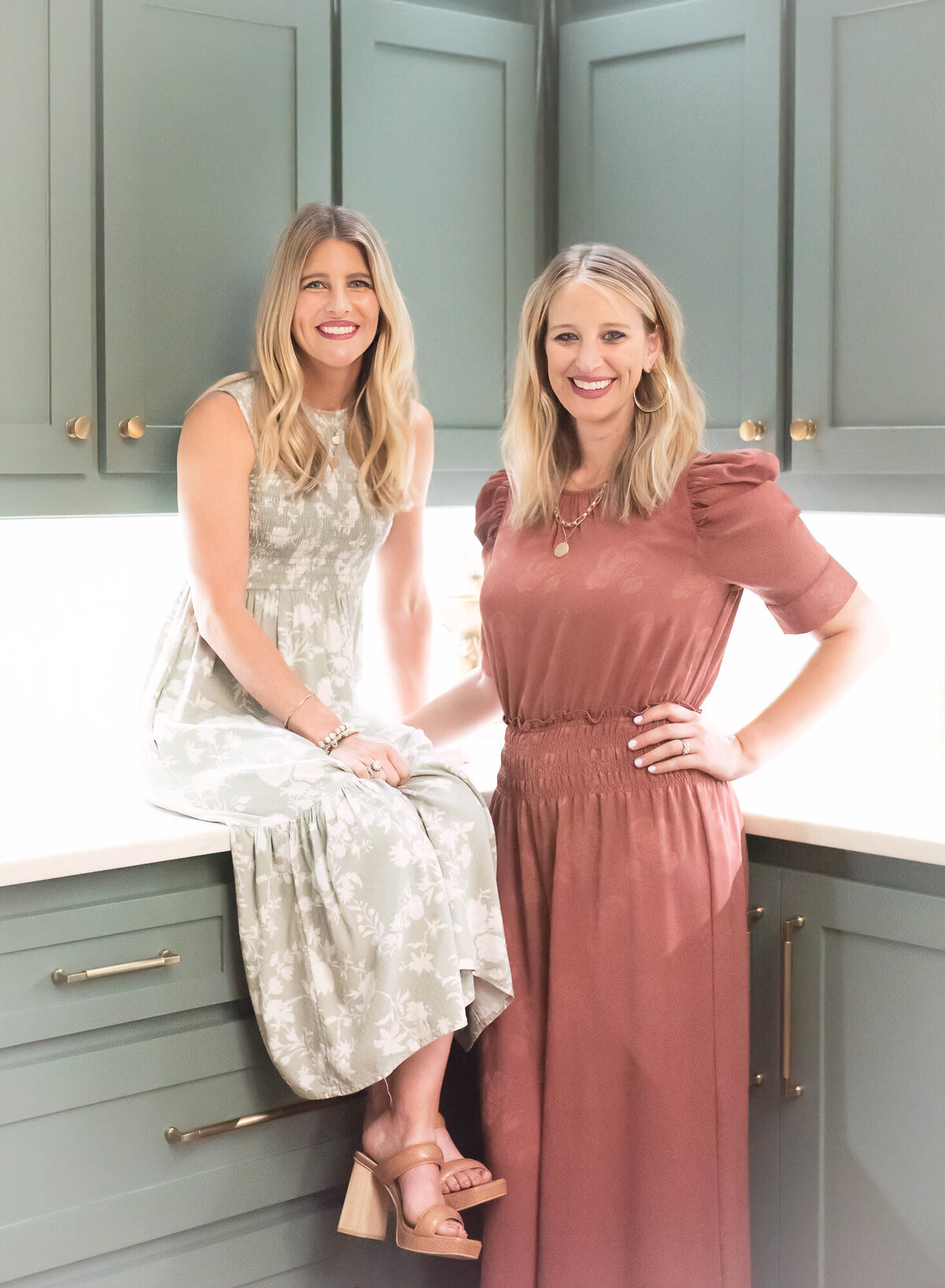 sister-owners of interior design company in the corner of the kitchen  smiling and looking happy