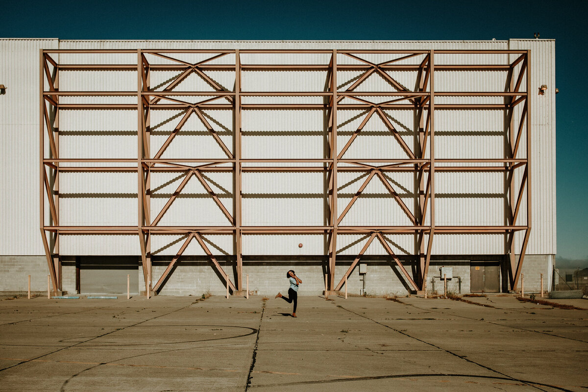 Wide angle lifestyle branding image of woman in Oakland industrial area