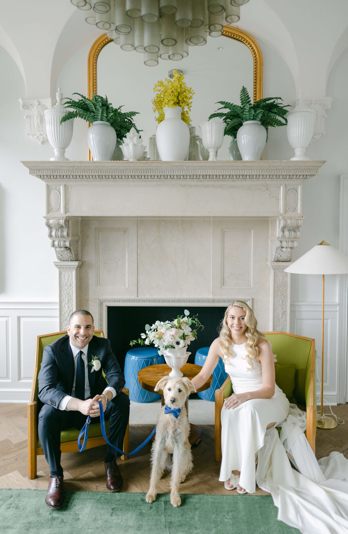 A bride and groom sit with their dog.