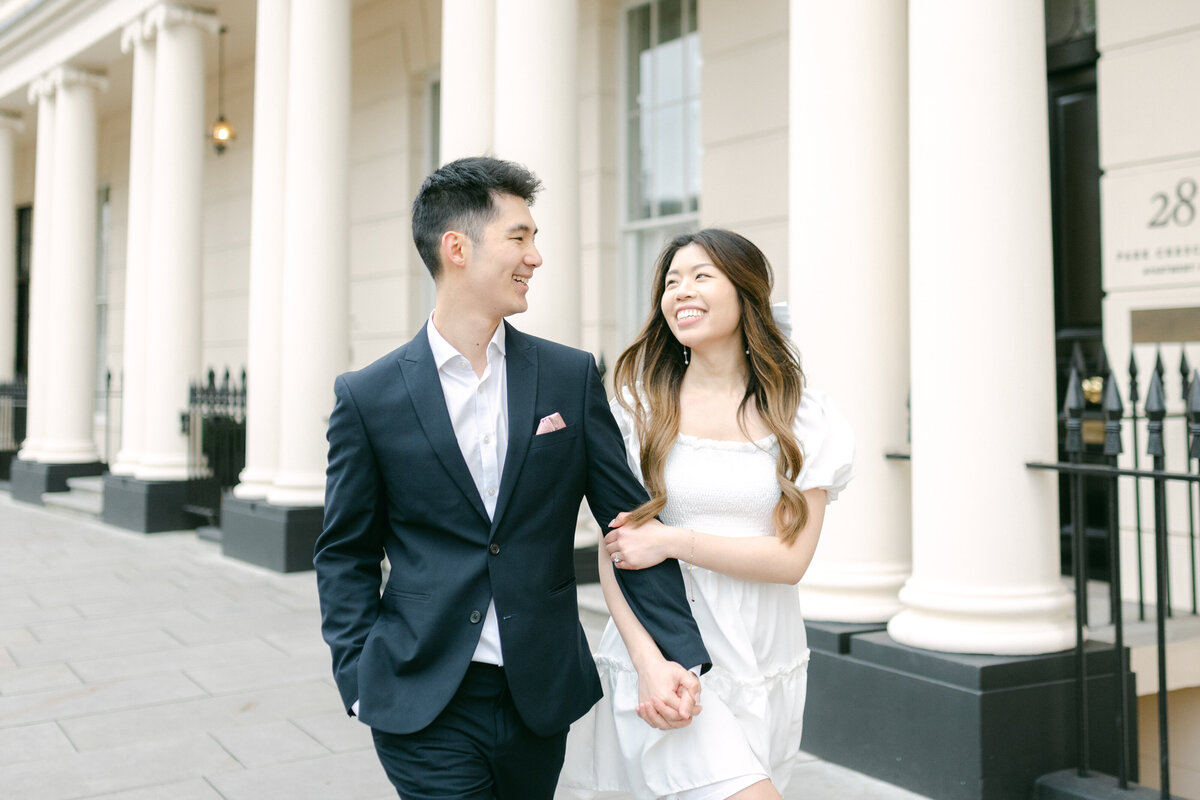Bride and groom are walking together in Marylebone in London looking at each other smiling