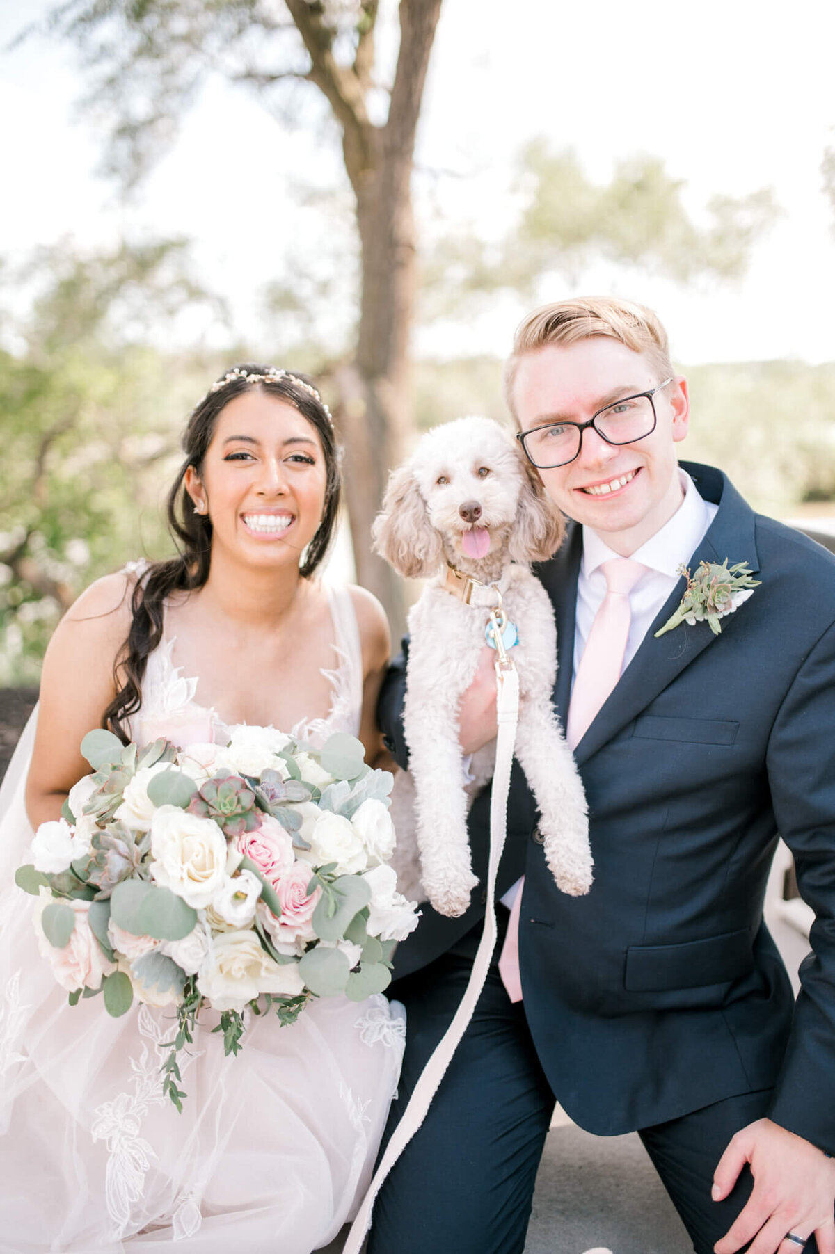 Bride and groom hold their dog who was part of their wedding day