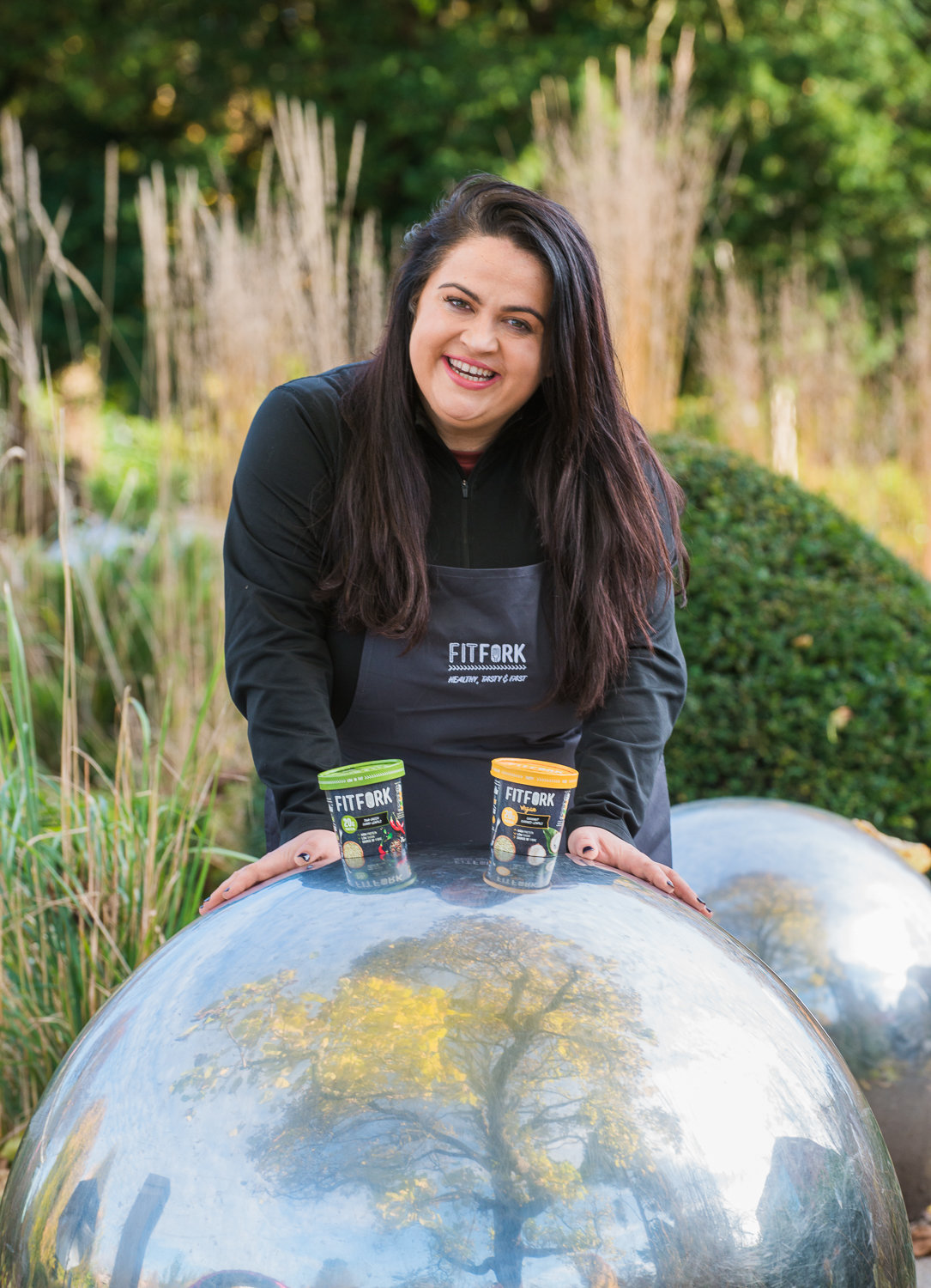 Female chef with black hair in a park promoting healthy food