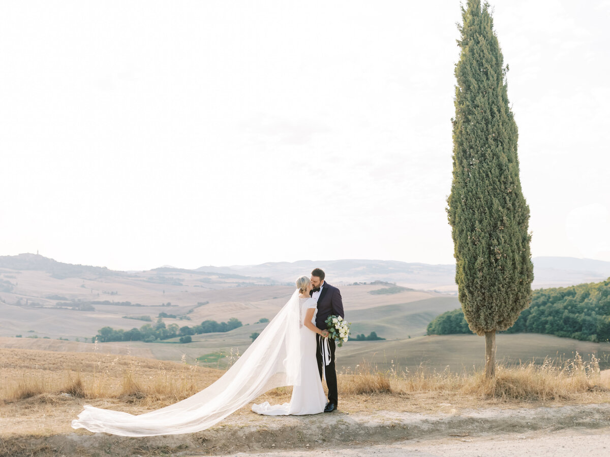 Bride and groom kissing in the countryside photographed by Chicago editorial wedding photographer Arielle Peters