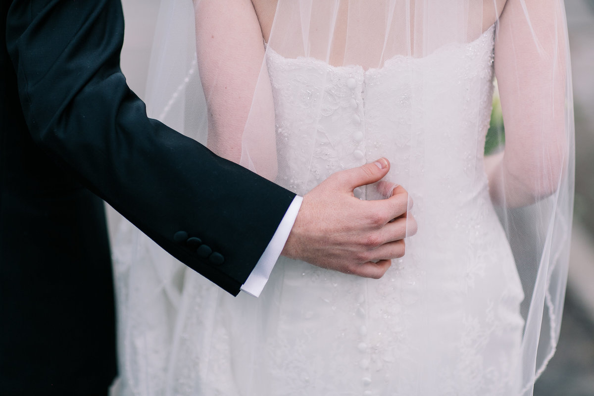 groom touching the small of his brides back in central park