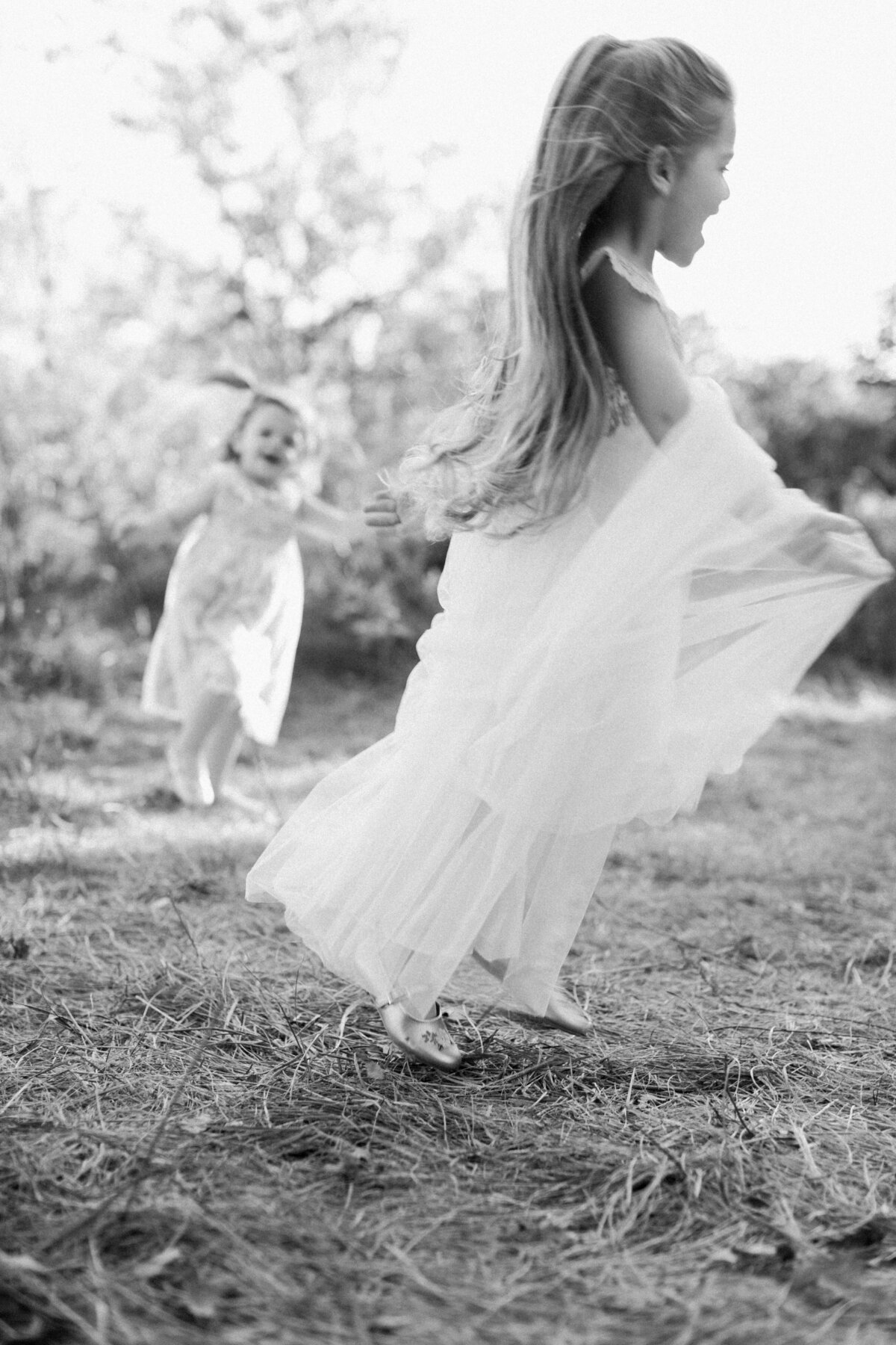 black and white image of little girl running and laughing