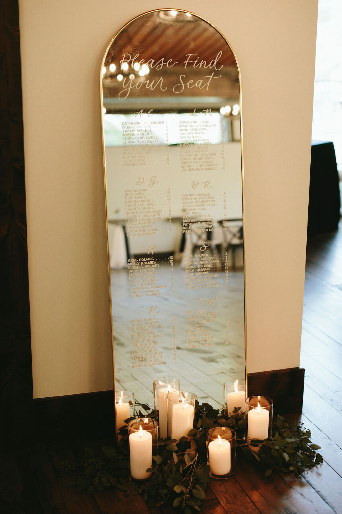 Modern, clean arched mirror with a wedding seating chart, for rent in Denver