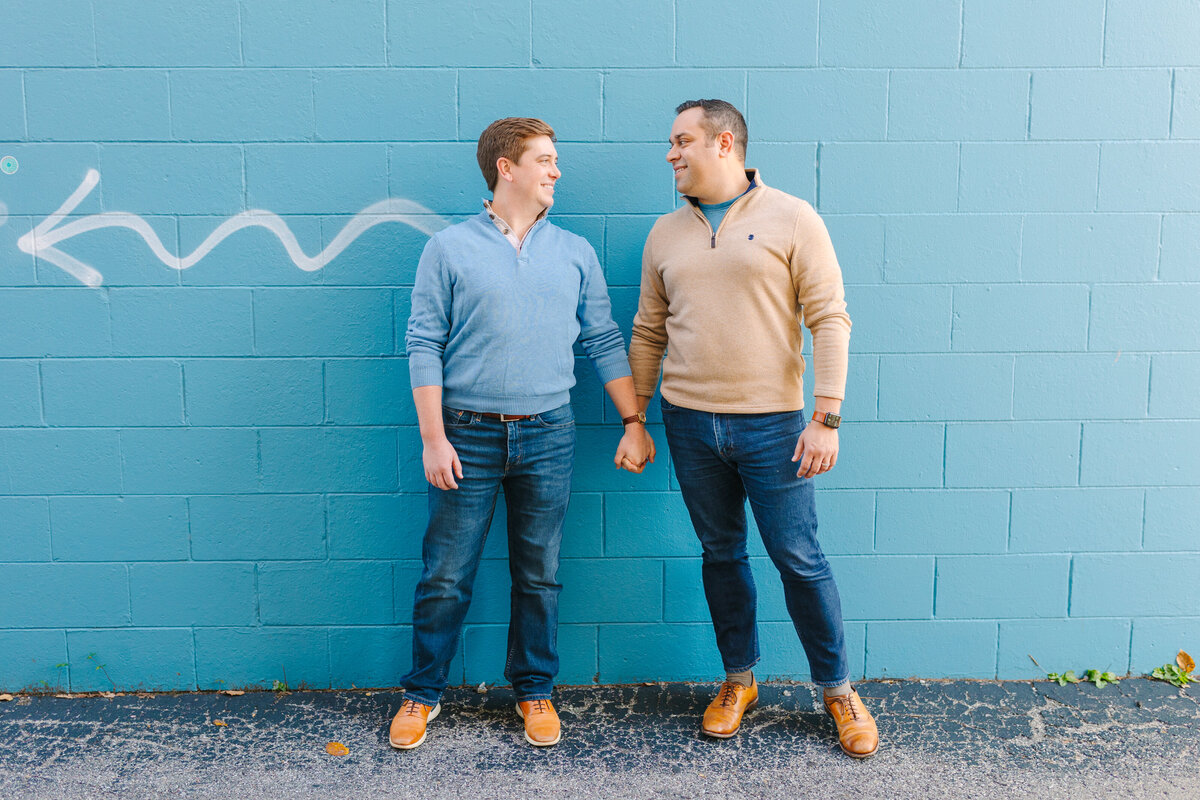 Gay couple in front of a blue wall