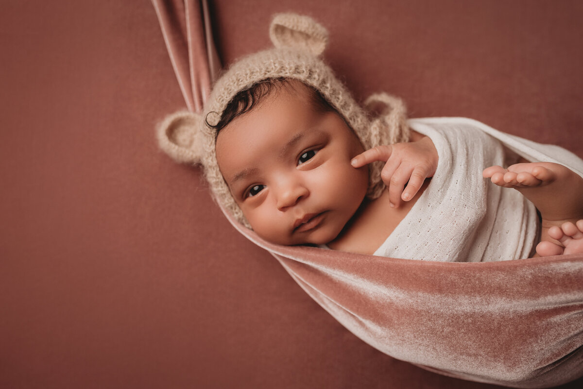 Newborn girl at Marietta, GA newborn photography studio awake and posed for newborn session in creams, tans and mauve