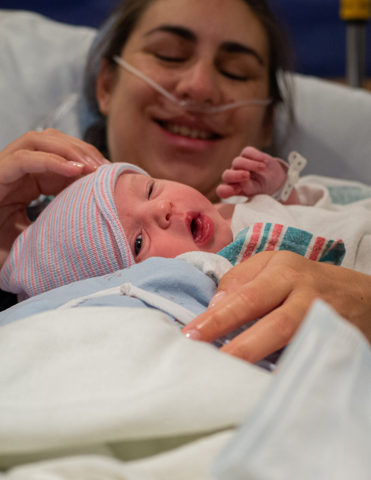 a new mother holds her baby for the first time after a c-section birth.