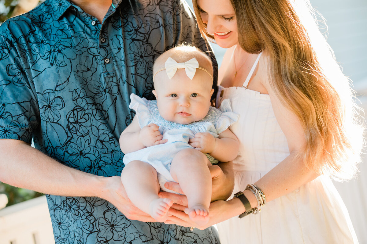 A small baby behind held up by two people