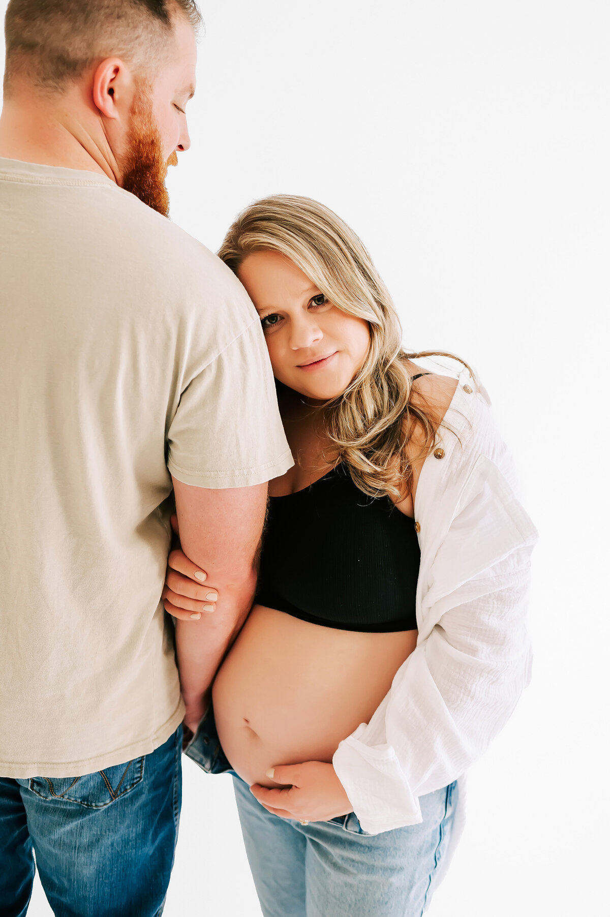 Pregnant mom leaning on husbands shoulder during Springfield MO maternity photographer Jessica Kennedy of The Xo Photography