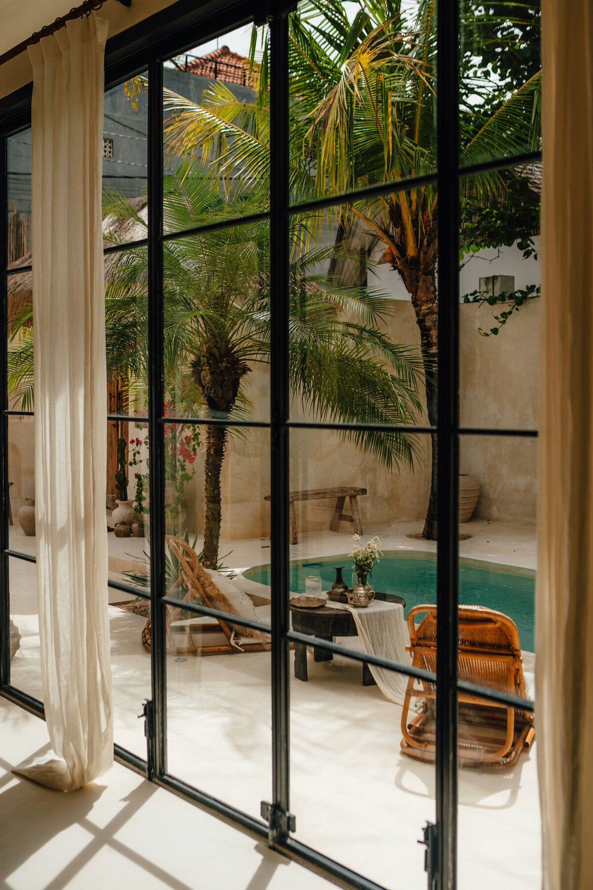 Glass wall with curtain that has pool view outside