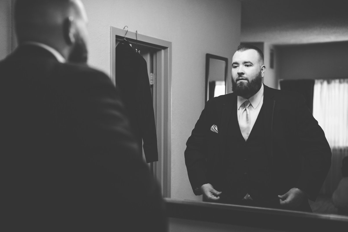 Groom Looks in the Mirror as he Gets Ready for his Tampa Bay Wedding