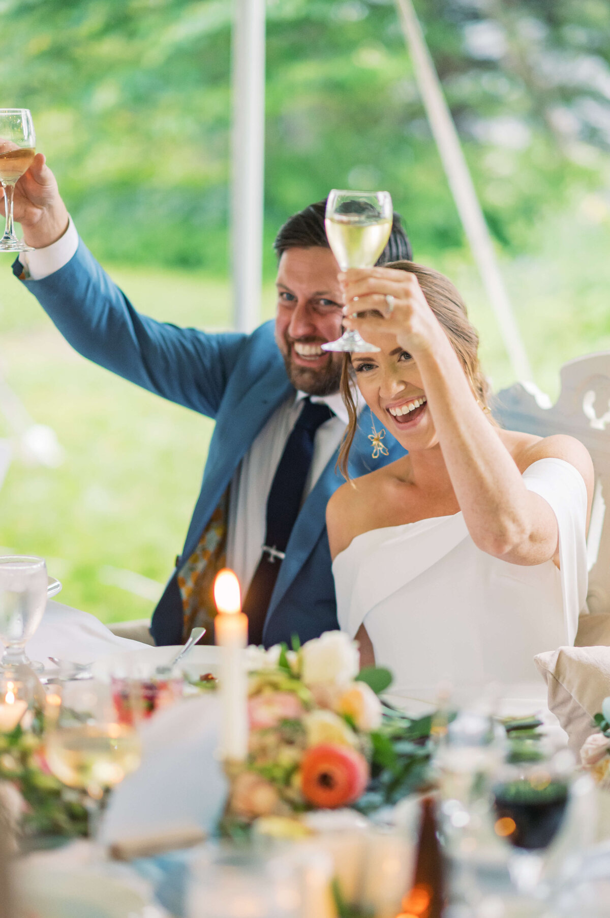 Bride and groom raising glasses at Oceanstone Resort Wedding reception in Nova Scotia