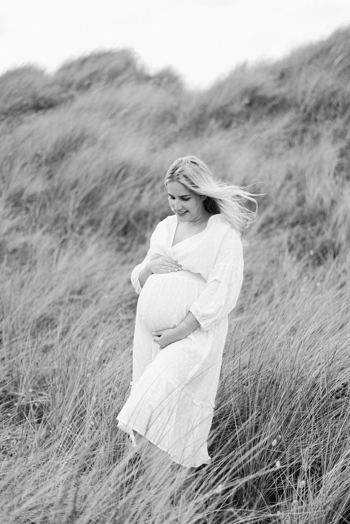 Black and white photo of a pregnant women holding her bump during a maternity photoshoot in Billingshurst