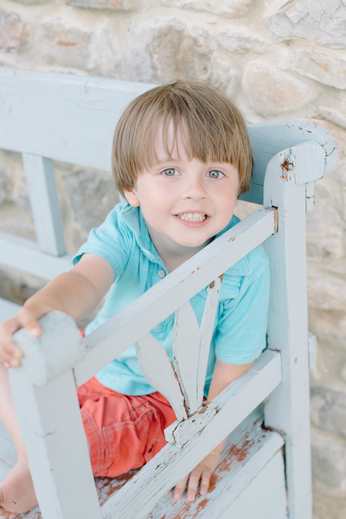 little boy sitting on light blue bench in Umbria, Italy