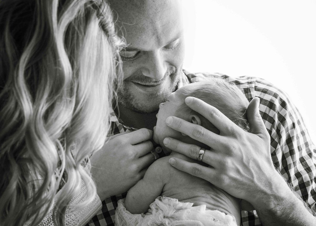 Sky 9 Studio | Documentary style black and white photo of new parents holding baby and comforting him during in-home lifestyle photo shoot