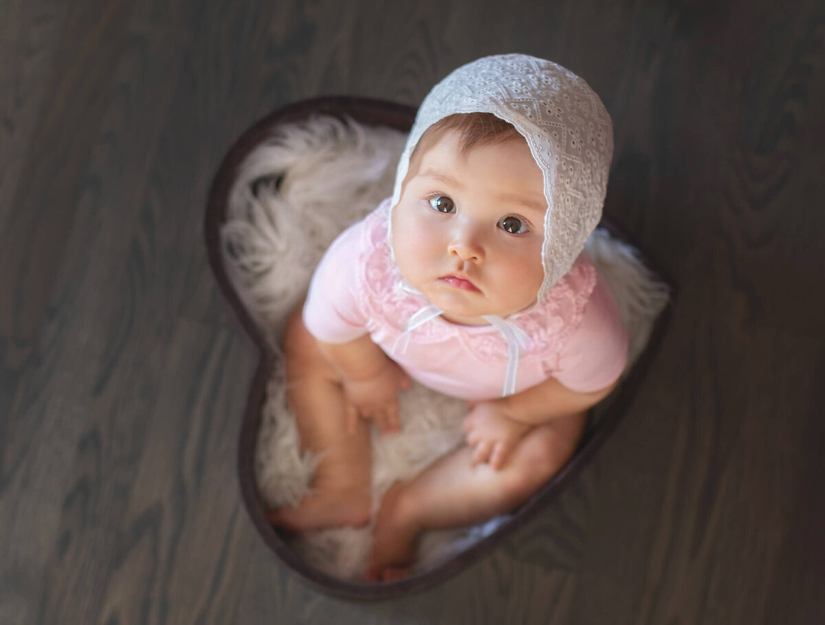 Baby in a heart bowl at her sitter session photoshoot in Woodland Hills