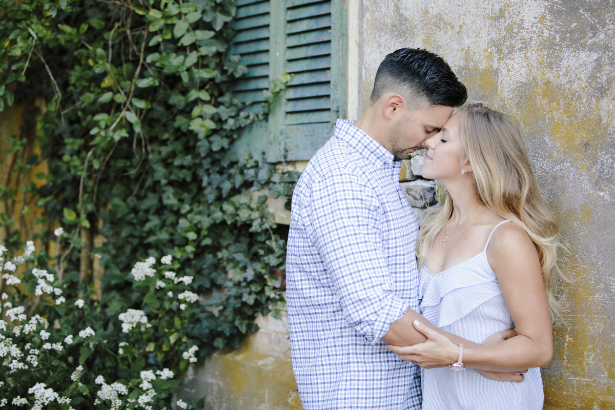 engaged couple kissing by old house at laurita winery
