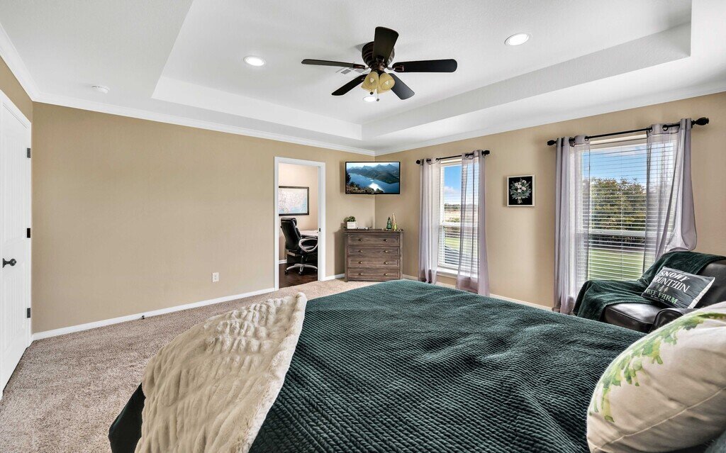 Bedroom with luxurious bedding and smart TV in this four-bedroom, four-bathroom vacation rental home and guest house with free WiFi, fully equipped kitchen, firepit and room for 10 in Waco, TX.