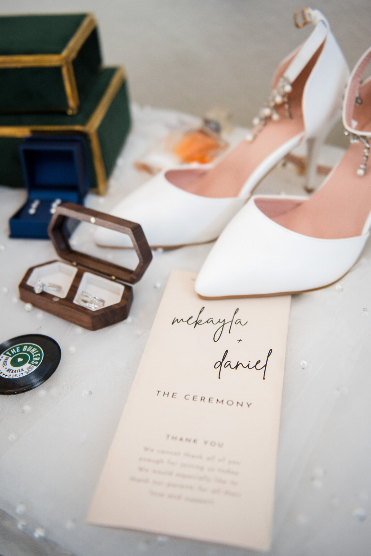 A collection of wedding details including a ceremony program, heels, and jewelry, captured by Denver wedding photographer, Two One Photography.