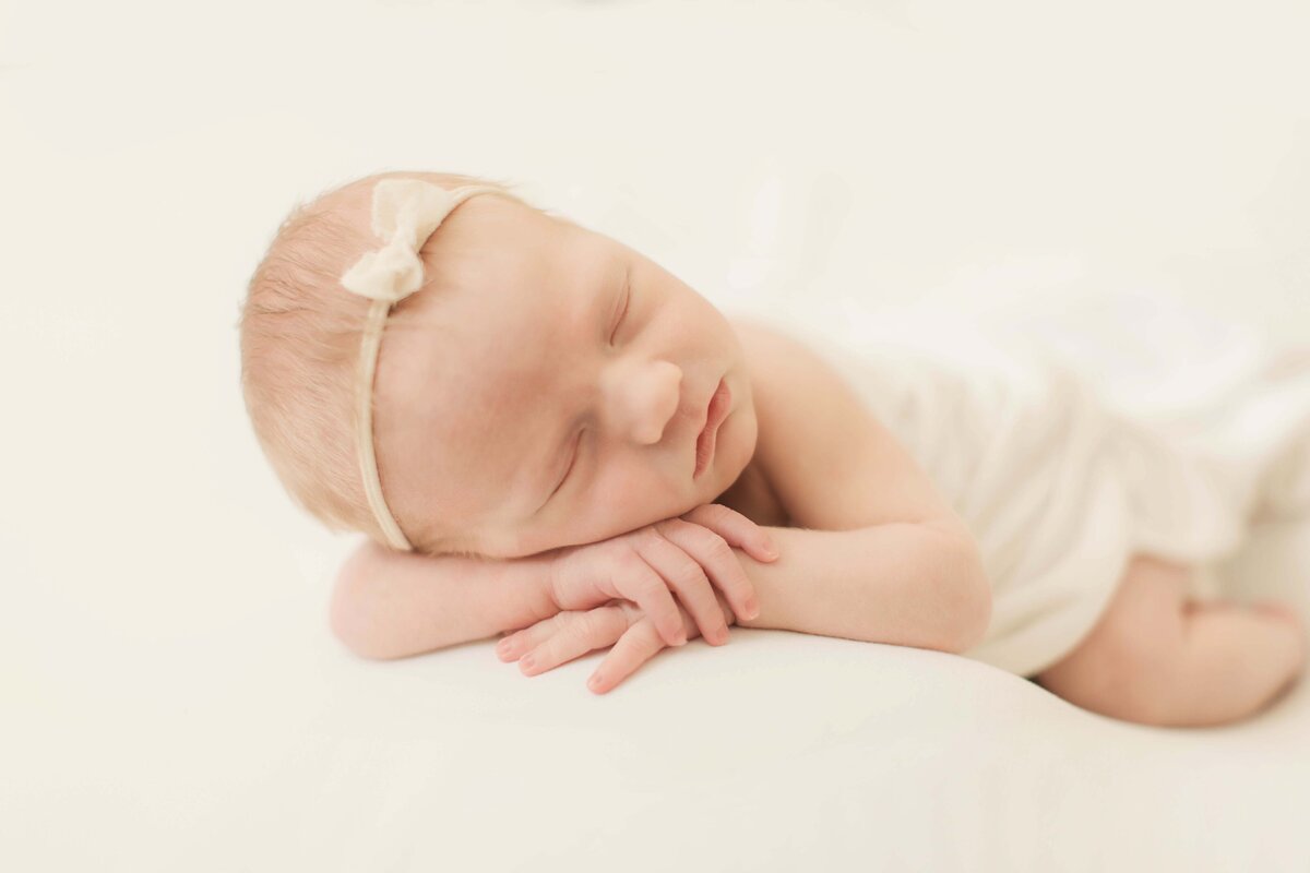 light and airy newborn photos in home Cincinnati baby posed on a backdrop