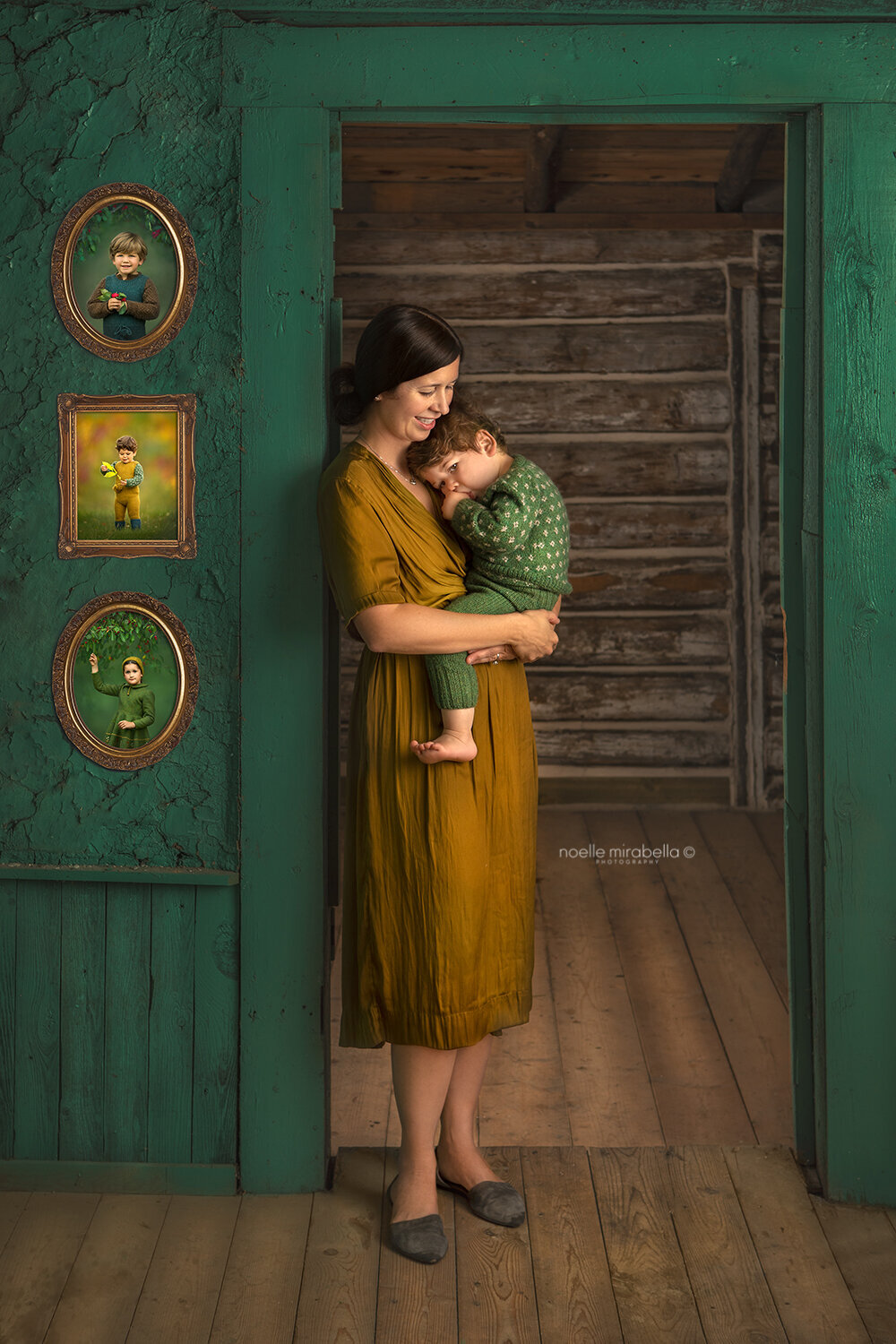 Mom snuggling her toddler in her arms in doorway of old teal house.