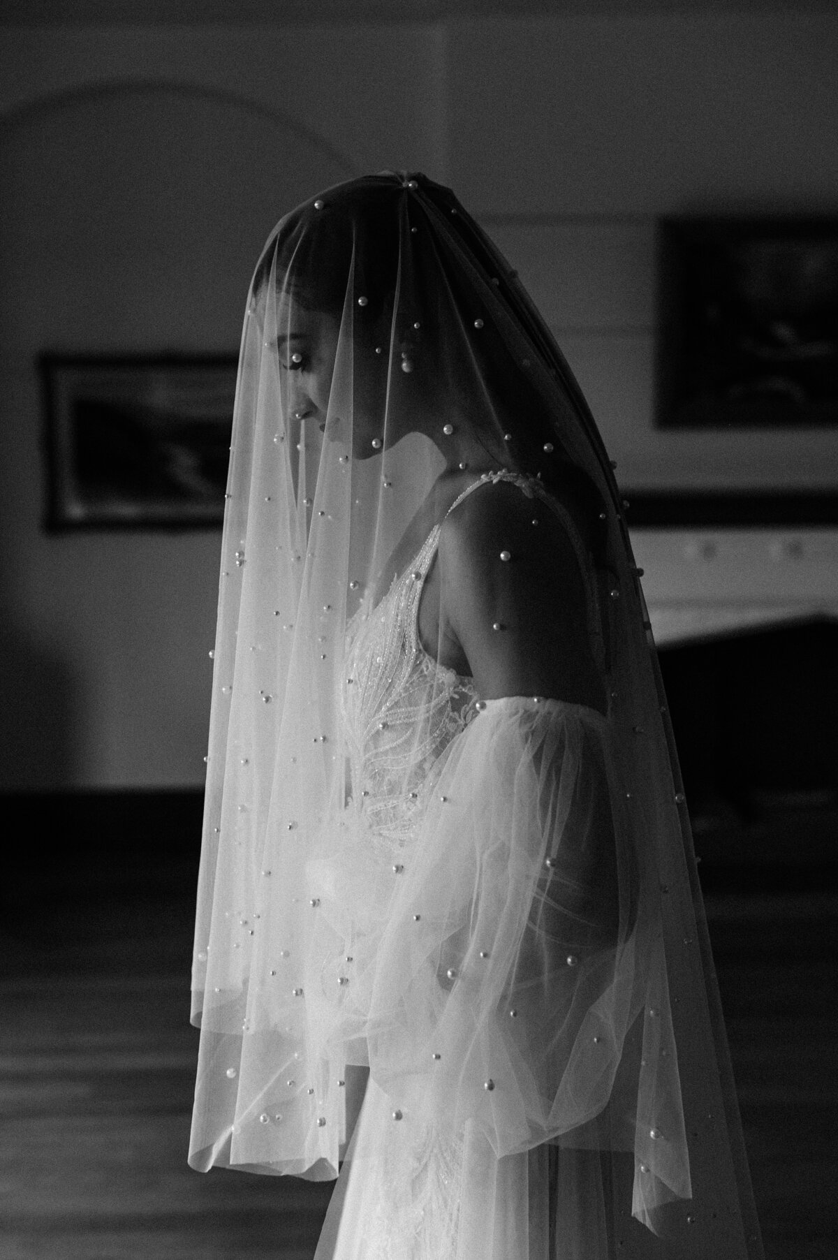 black and white photo of bride with pearl veil over face in art gallery in christchurch nz with removable sleeves