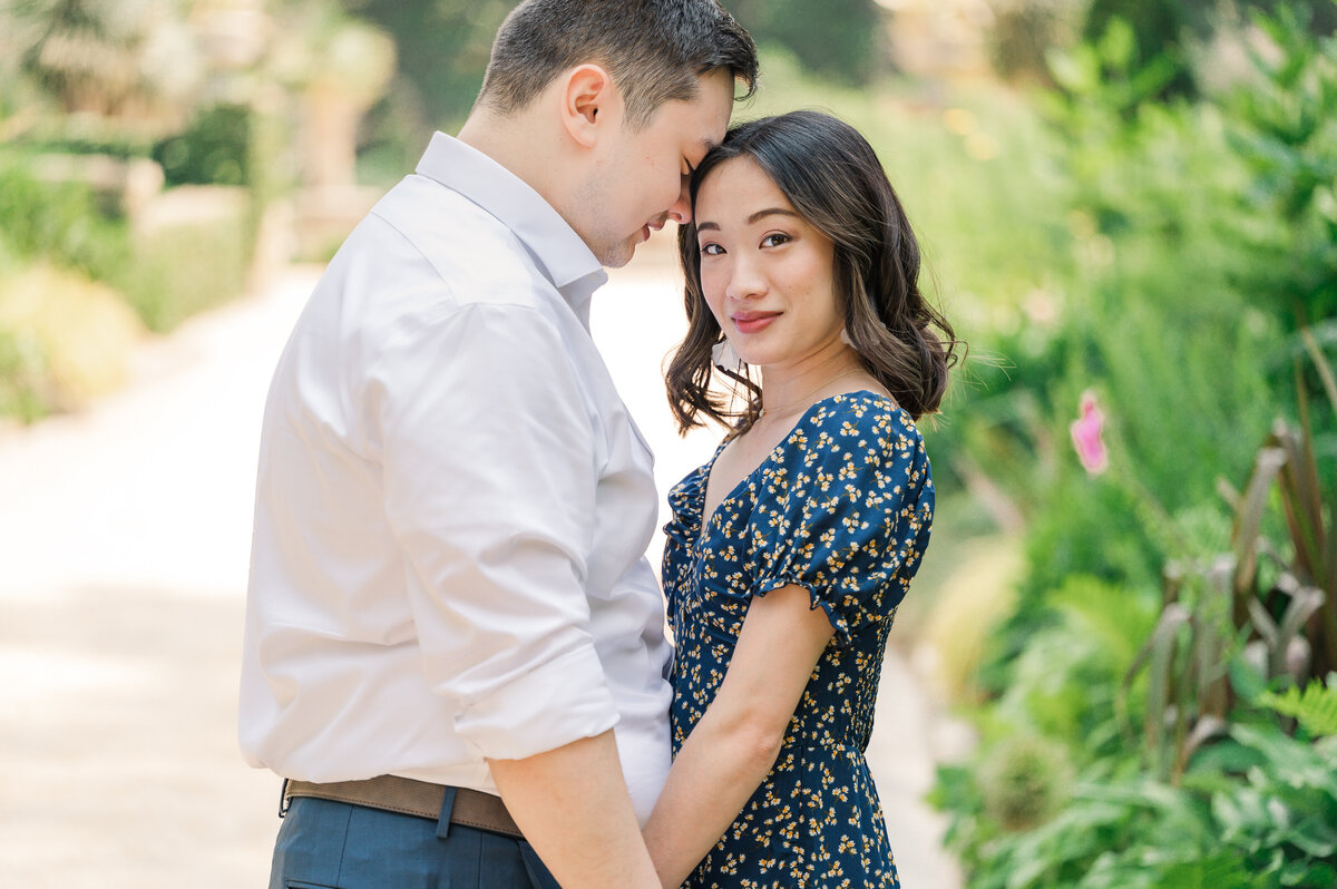 An Asian couple in Duke Gardens celebrating their recent engagement session by JoLynn Photography, a North Carolina wedding photographer