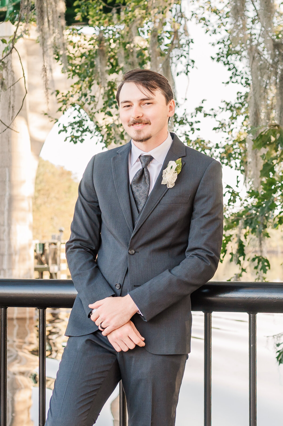 A groom's wedding portraits under the Spanish moss trees at sunset on his wedding day by JoLynn Photography, a Raleigh wedding photographer