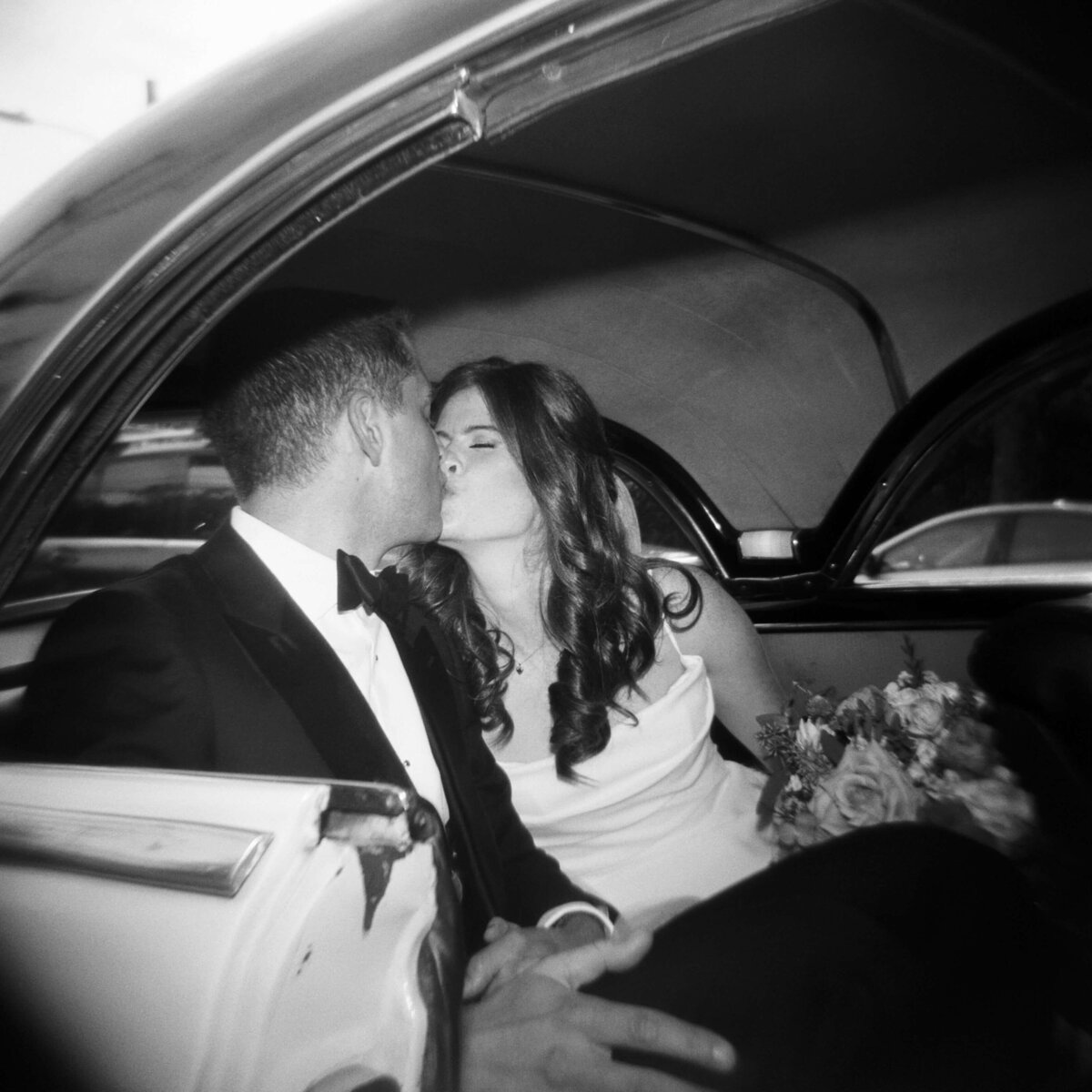 Bride and groom kissing in wedding car at Halifax wedding, Nova Scotia