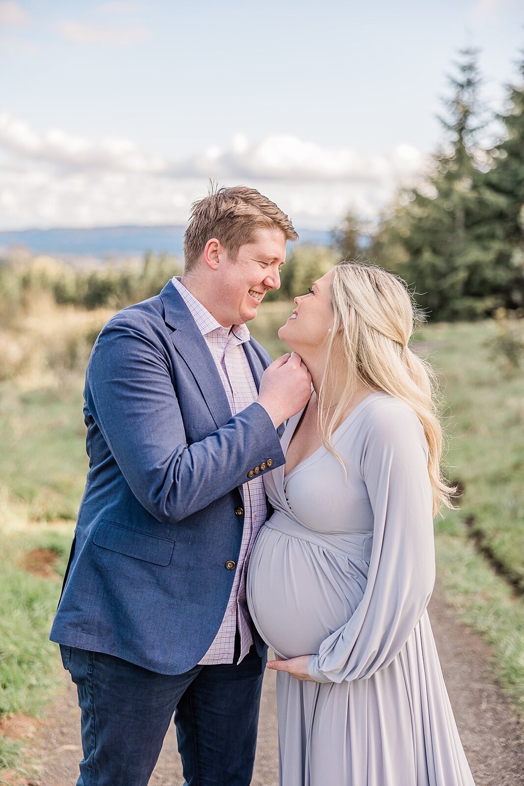 husband with hand on wife's chin looking at each other in sweet maternity session in beaverton oregon