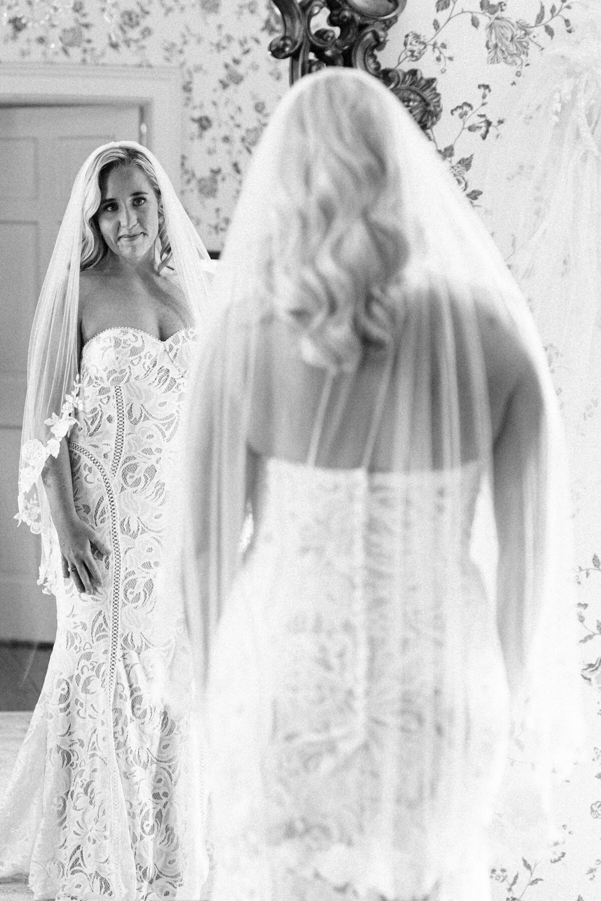 bride smiling at herself in the mirror wearing wedding dress and veil winx photo knoxville wedding photographer
