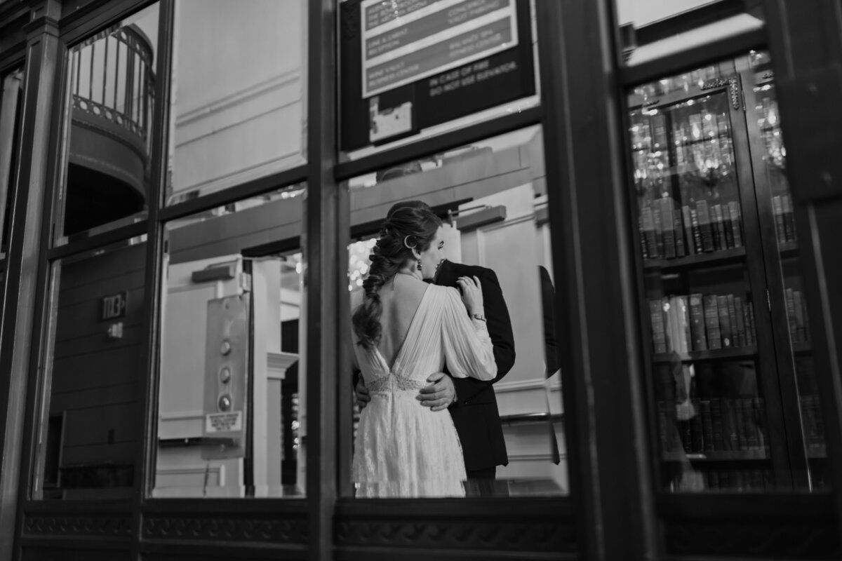 A black & white mirror reflection of a bride and groom at Hotel ICON in Houston Texas. Captured by Fort Worth wedding photographer, Megan Christine Studio