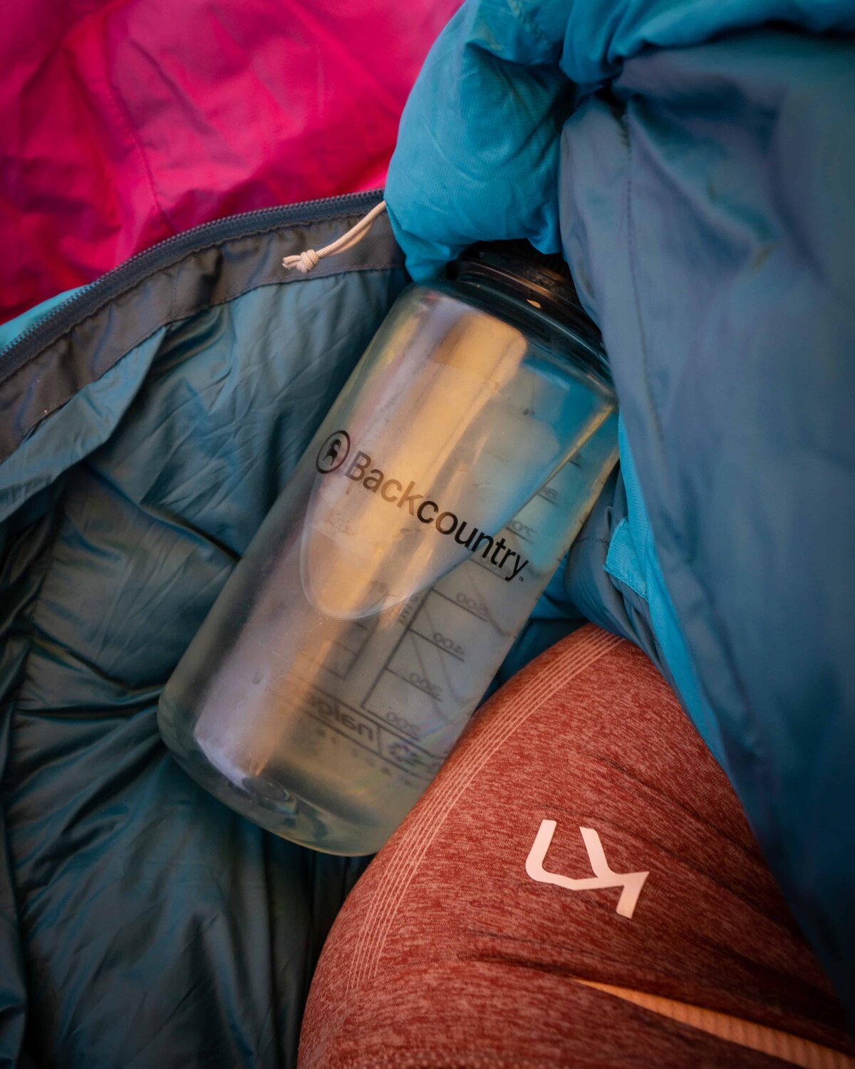 Clear Backcountry water bottle inside a dark colored backpack
