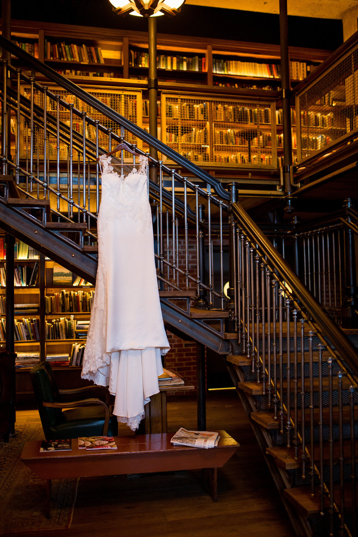Bridal gown hanging on staircase in library at The Hotel Emma wedding venue in The historic Pearl in down town san antonio