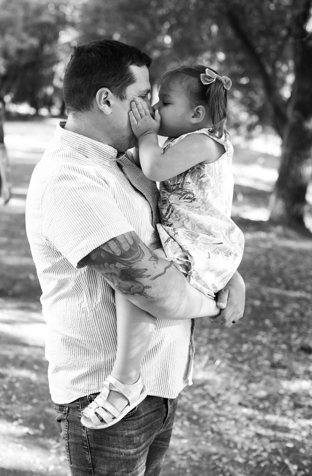 little girl kissing her daddy. Raleigh portrait photography.