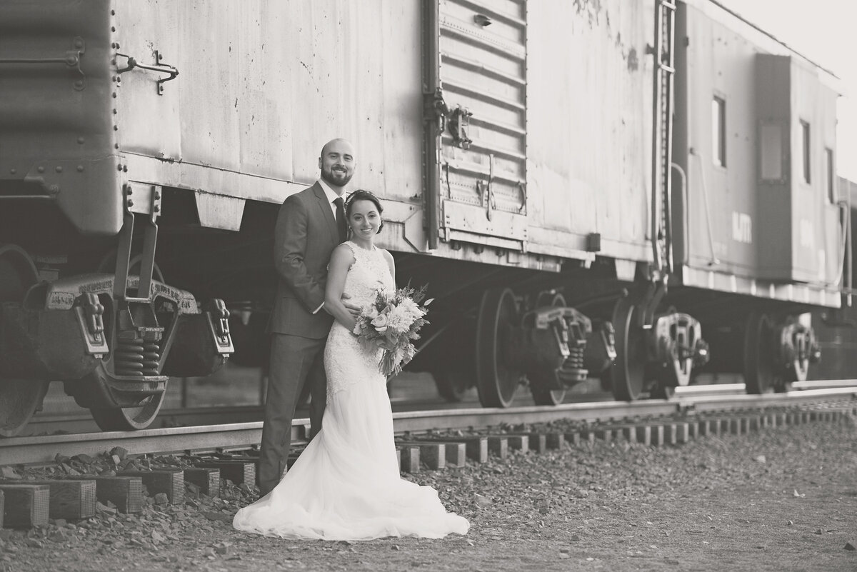 bride and groom smiling by a train at Maritime Parc