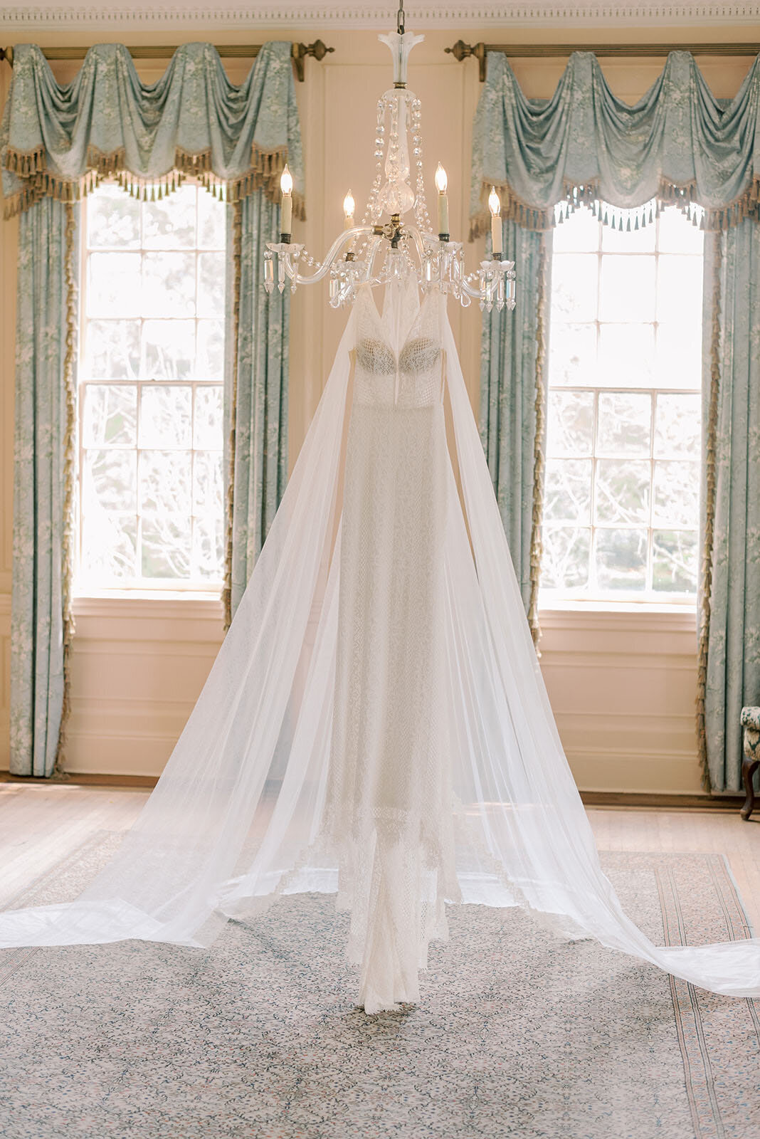 lace wedding gown hanging from chandelier