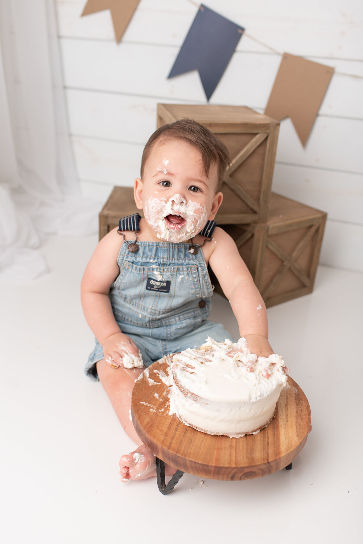Baby smiling at camera with cake all over his face